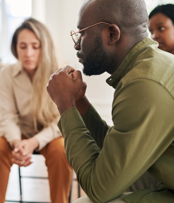 side-view-of-young-stressed-man-with-interlocked-hands-by-face-attending-session.jpg